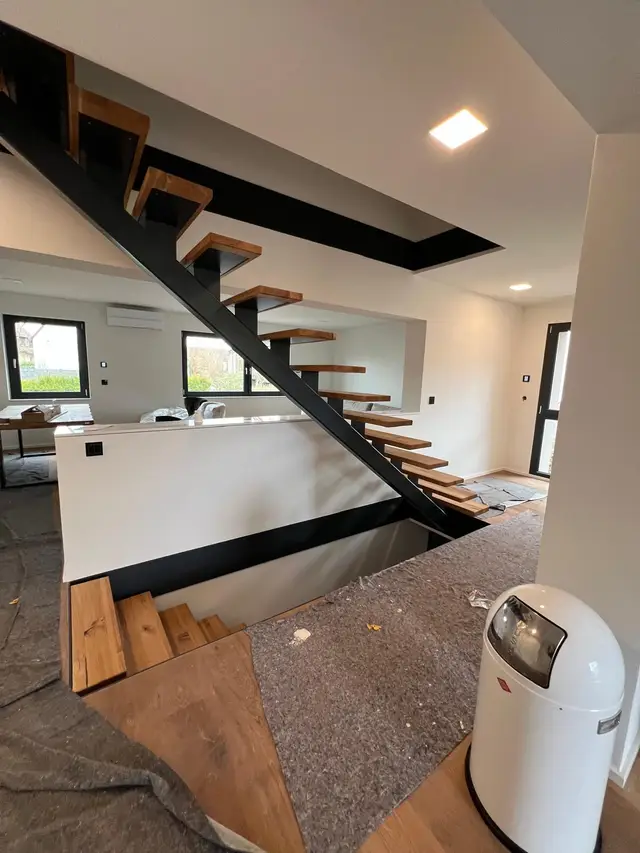 Freitragende Mittelsteg-Stahltreppe mit Holzstufen und Stahlflach-Umrandung